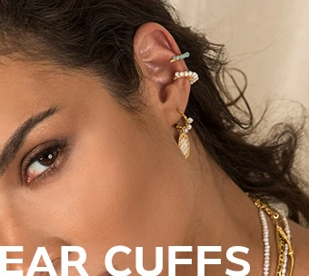 Γυναίκα που φοράει μοντέρνα ear cuffs με πέρλες και χρυσές λεπτομέρειες, συνδυασμένα με διακριτικά κοσμήματα.